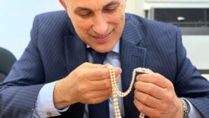 Afshin Shaddaie holding rare natural saltwater pearl necklace